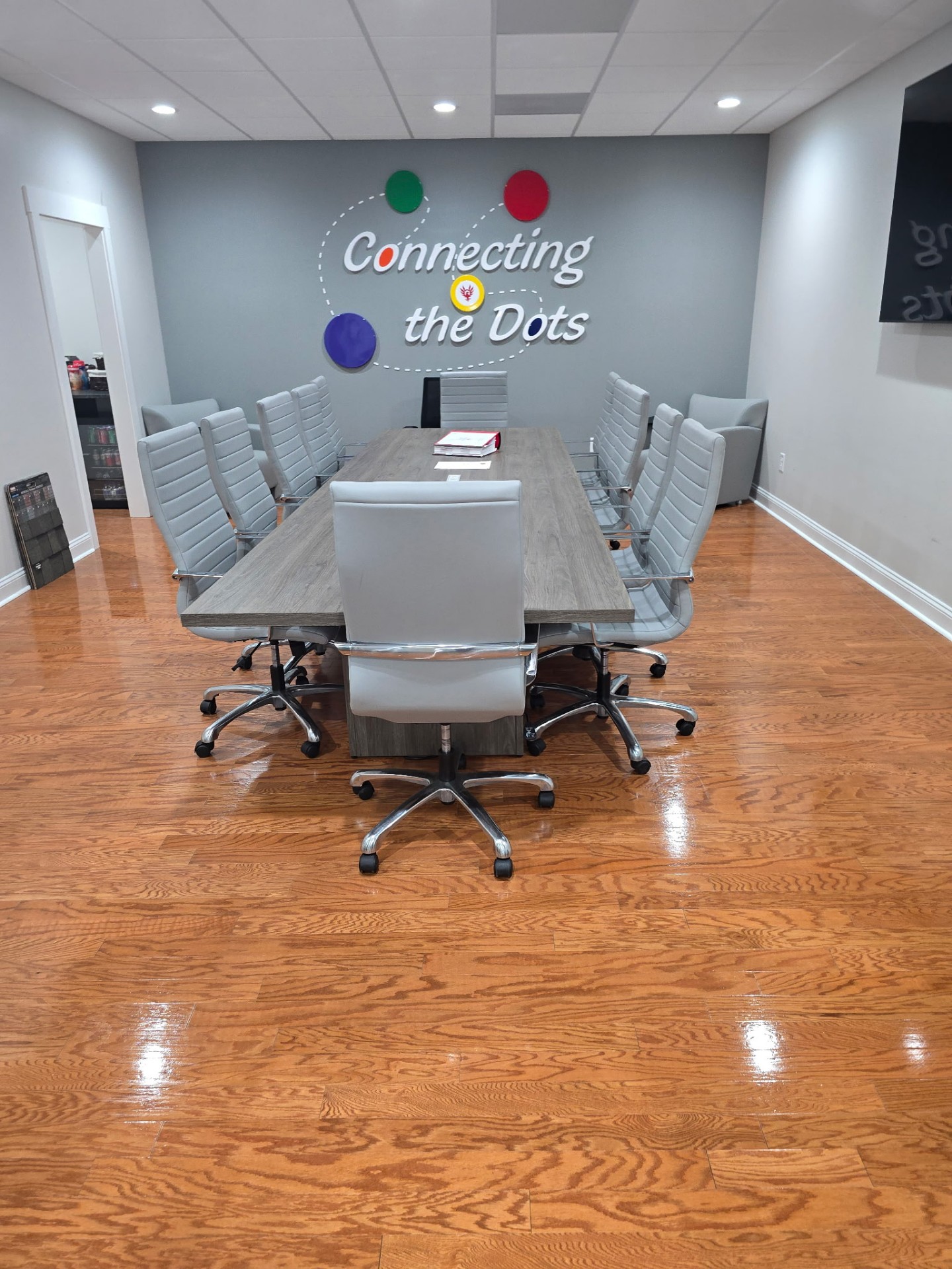 Polished conference room with long wooden table and freshly cleaned hardwood floors